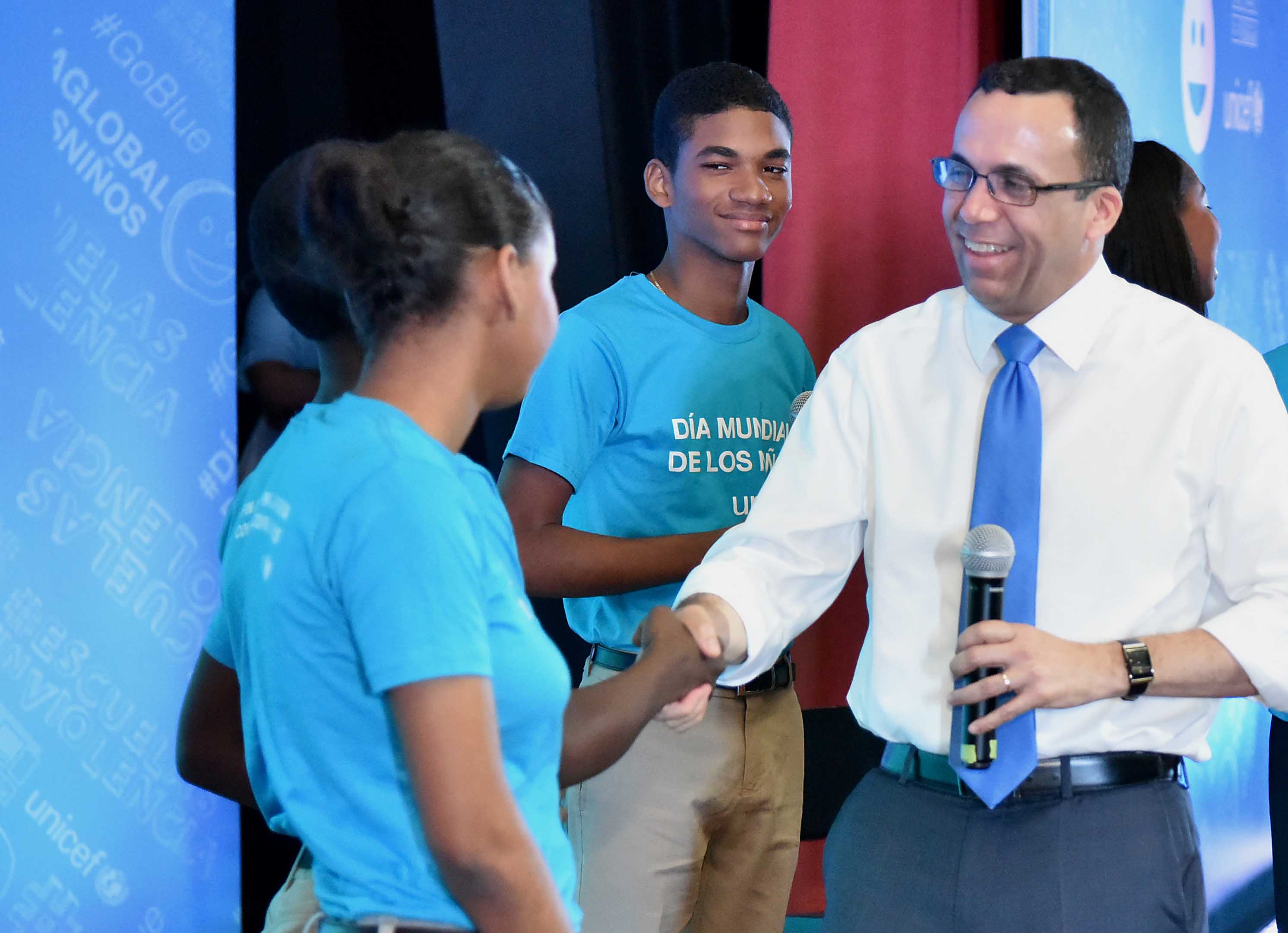  imagen Ministro Andr&eacute;s Navarro de pie en tarima junto a estudiantes tomandose una selfie 