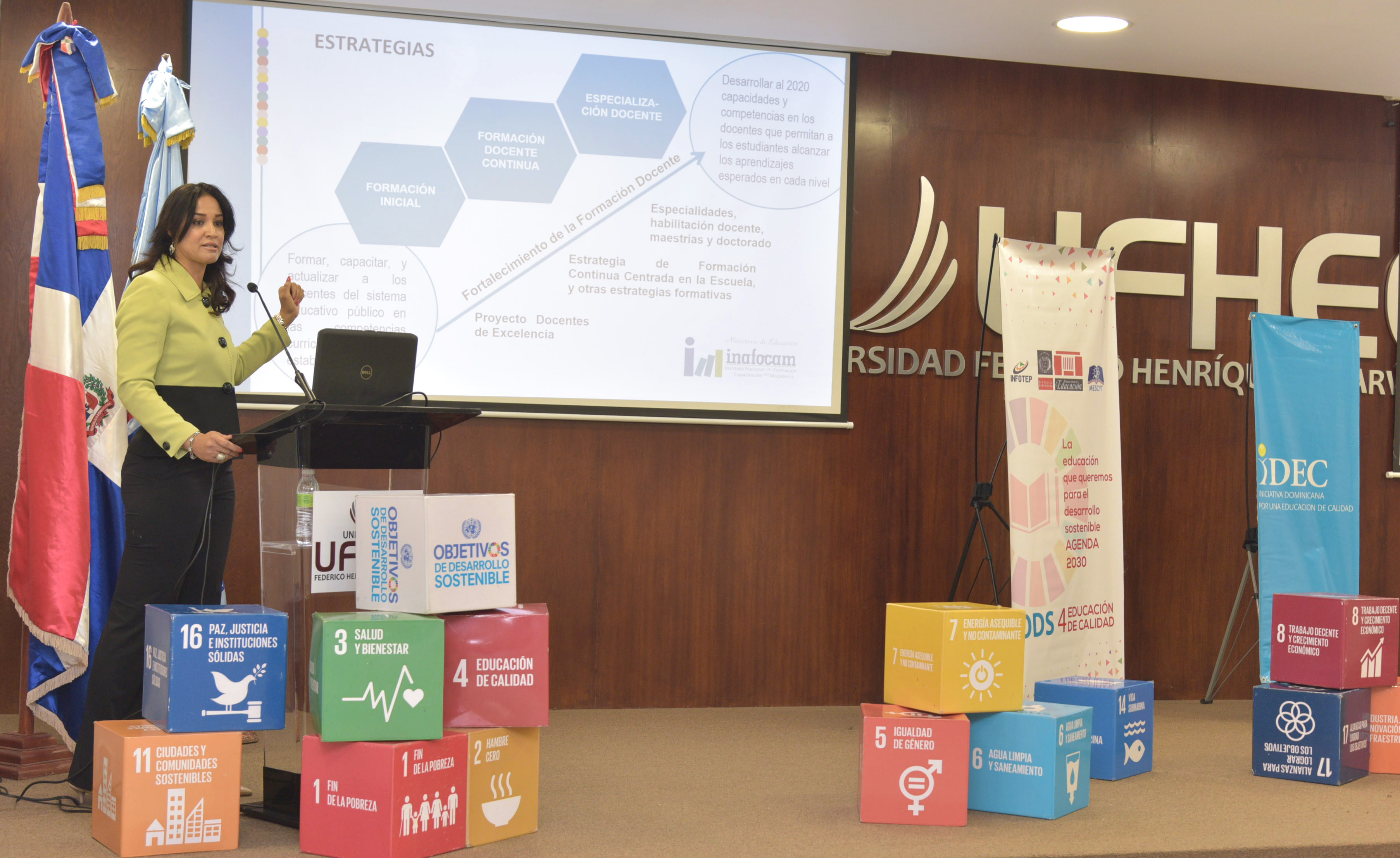  imagen &nbsp;Mujer de pie en podium dirigiendo discurso sobres los ODS 