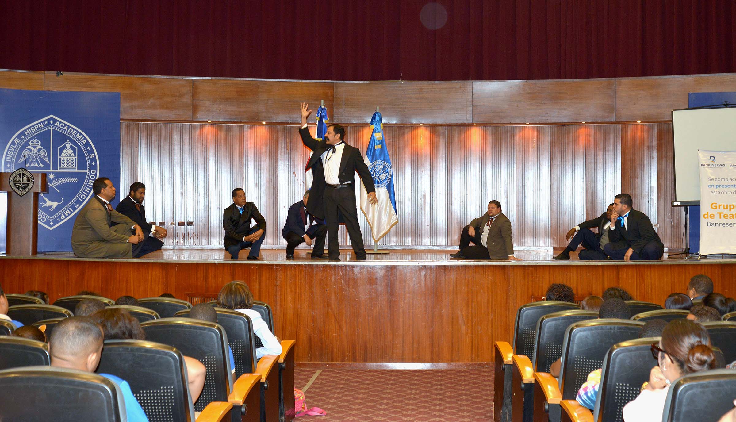  imagen Conferencista de pie en podium se dirife a estudiantes sentados 
