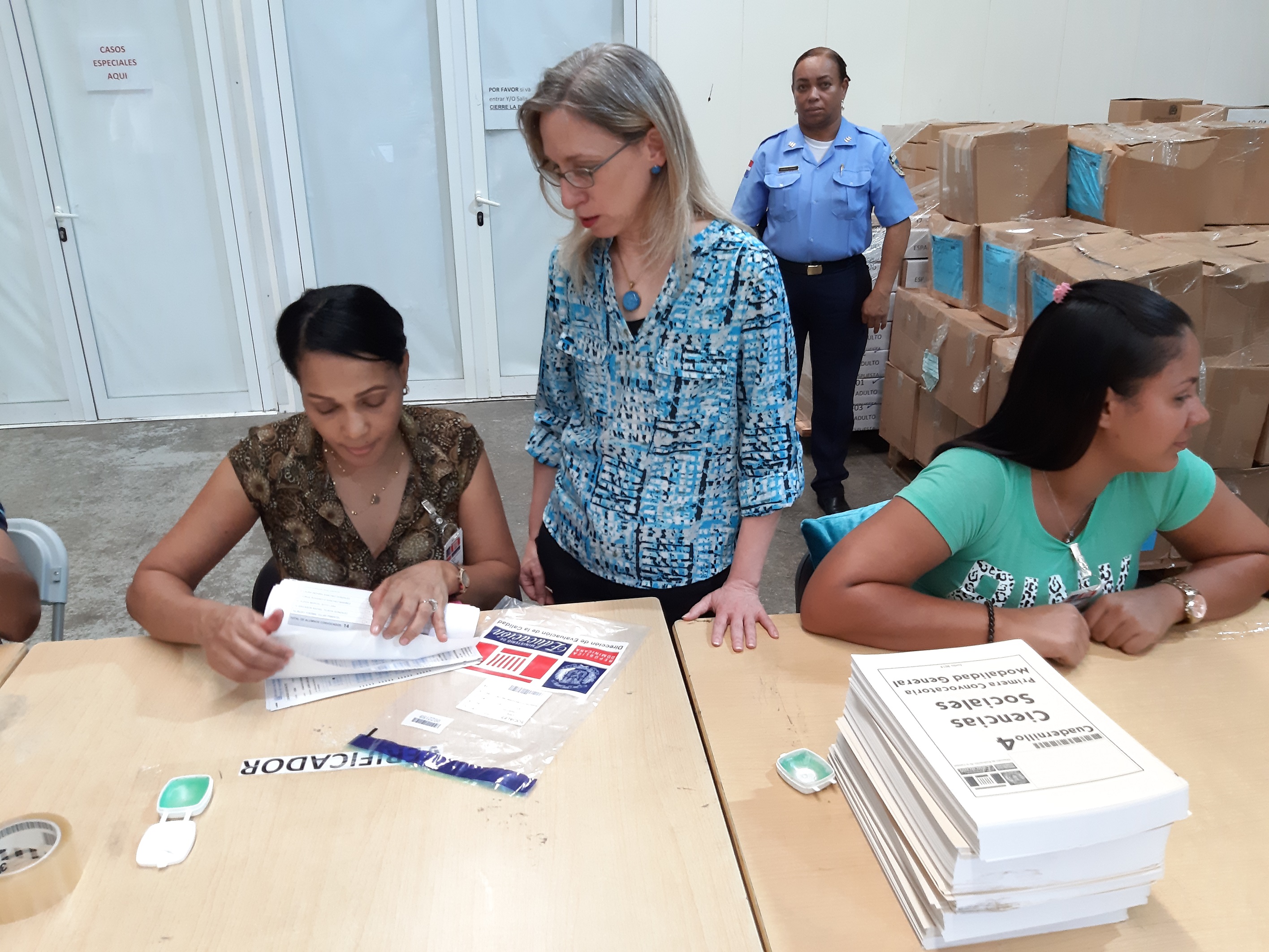  imagen Ministro de Educaci&oacute;n Pe&ntilde;a Mirabal junto a Directora de Evaluaci&oacute;n de la Calidad Educativa Ancell Scheker, verifican cuadernillo de pruebas&nbsp;durante recorrido por las instalaciones en las que se encuadernan y empacan. 