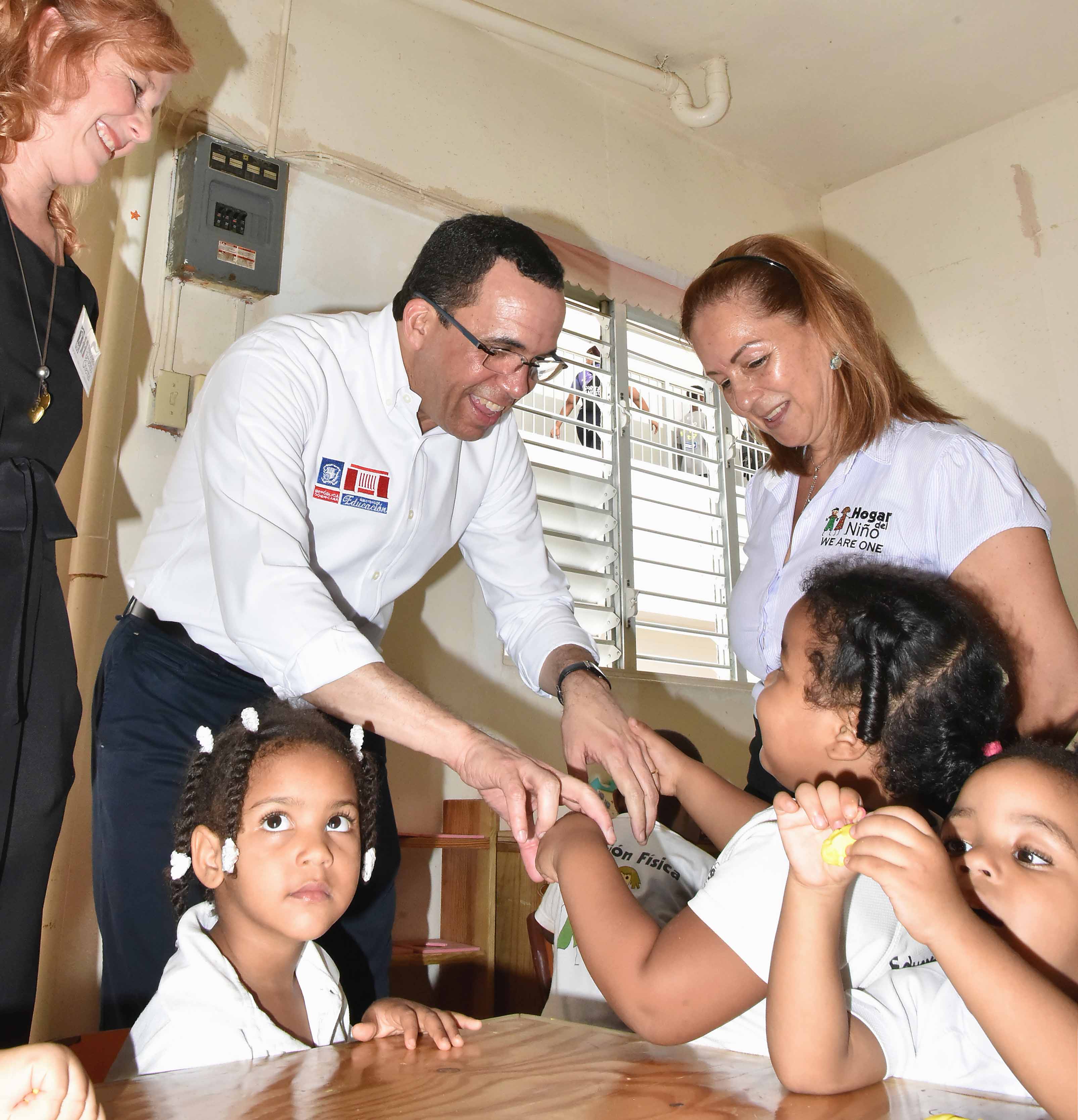  imagen Ministro Andr&eacute;s Navarro soriendo mientras carga a ni&ntilde;o rodeado por miembros del Patronato Ben&eacute;fico Oriental. 