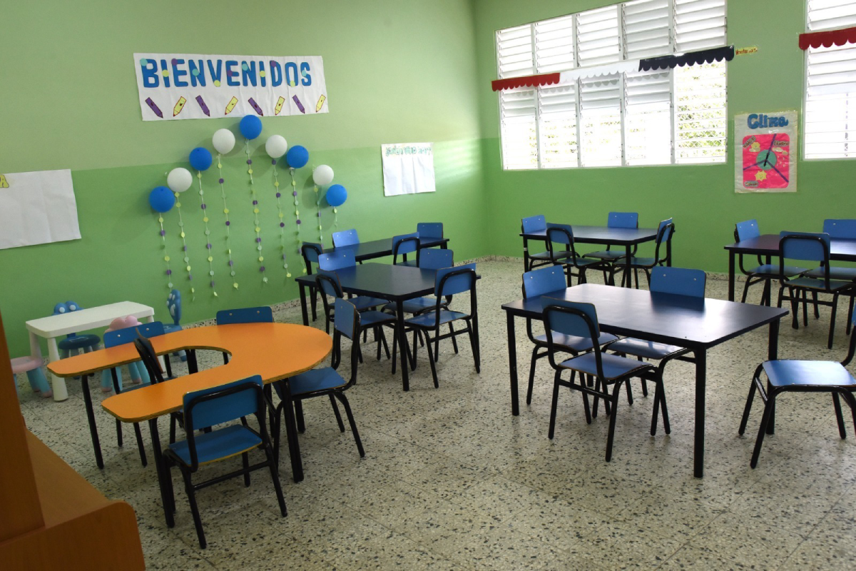  imagen Randa Rosario y Antonio Marcelino junto a dos estudiantes, durante corte de cinta en la entrada del aula. 