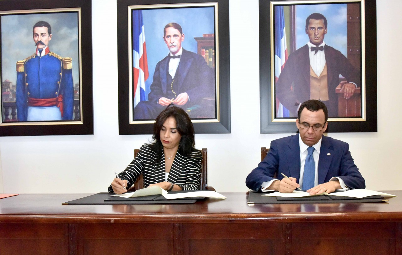  imagen Ministro Andr&eacute;s Navarro y Directora de INTRANT, Claudia Franchesca De Los Santos sentados firmando acuerdo interinstitucional&nbsp; 