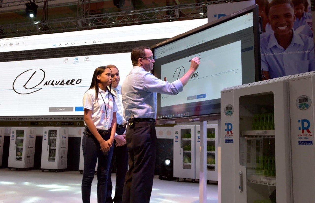  imagen Ministro Andr&eacute;s Navarro junto a estudiantes de pie firmando carta compromiso en pantalla digital para impulsar una Ciberciudadan&iacute;a Responsable&nbsp; 