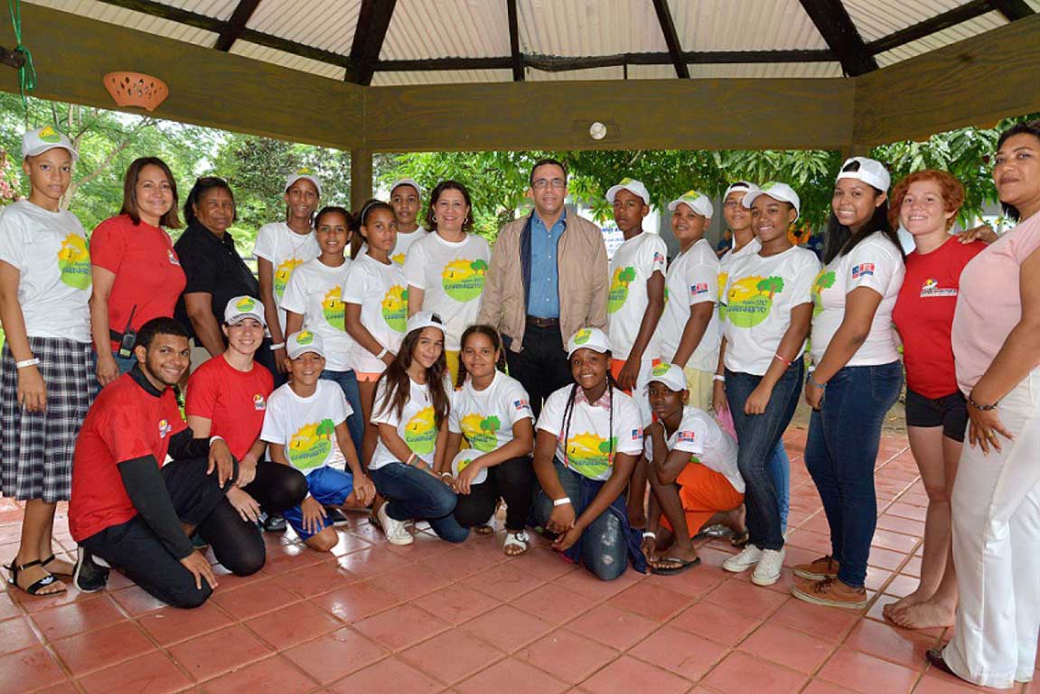  imagen Ministro Andr&eacute;s Navarro junto a grupo de estudiantes en el Campamento de Verano Aventura, todos sonrien. 