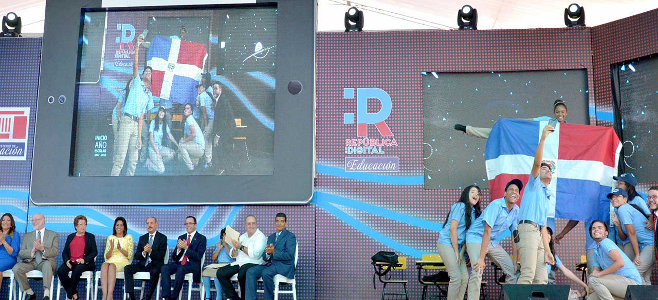  imagen Fotograf&iacute;a tomada durante la&nbsp;ceremonia celebrada en el nuevo Polit&eacute;cnico Do&ntilde;a Rosario Rojas de Contreras. A la izquierda en la im&aacute;gen, el Presidente Danilo Medina acompa&ntilde;ado de la Primera Dama, C&aacute;ndida Montilla de Medina y el Ministro de Educaci&oacute;n, Andr&eacute;s Navarro, junto a otros miembros de su Gabinete. A la derecha&nbsp;grupo de estudiantes tomandose una selfie luego de concluido su acto. 
