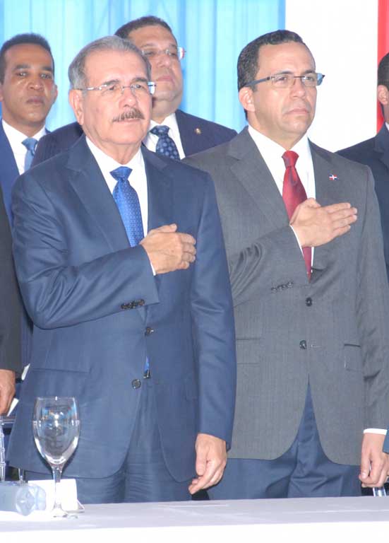  imagen Presidente Danilo Medina y Ministro Andr&eacute;s Navarro colocan su mano derecha en lado izquierdo de sus pechos, en se&ntilde;al de respeto hacia el himno nacional. 