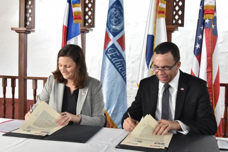  imagen Ministro Andr&eacute;s Navarro y la representante del Cuerpo de Paz de Estados Unidos, Kristin Kaper sentados firmando acuerdo de entendimiento para llevar voluntarios a las escuelas.&nbsp; 