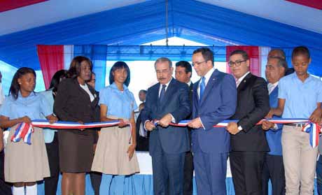  imagen Presidente Danilo Medina mientras corta cinta en acto de inauguraci&oacute;n, a su lado izquierdo Ministro Andr&eacute;s Navarro sostiene un extremo de la cinta; con ellos otras personalidades invitadas. 