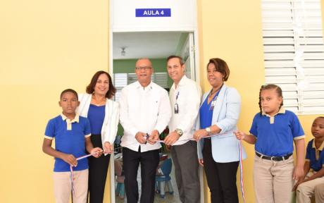  imagen Randa Rosario y Antonio Marcelino junto a dos estudiantes, durante corte de cinta en la entrada del aula. 