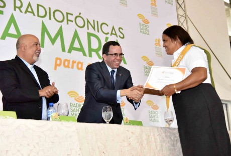  imagen Ministro Andr&eacute;s Navarro desde mesa principal parado d&aacute;ndole la mano a una graduando de la Escuela Radiof&oacute;nica&nbsp; 